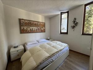 - une chambre avec un lit et une photo sur le mur dans l'établissement Appartamento Patascoss, à Madonna di Campiglio