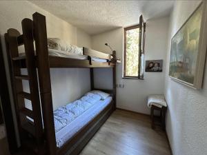 a room with two bunk beds and a window at Appartamento Patascoss in Madonna di Campiglio