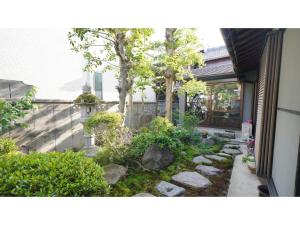 um jardim com pedras e árvores em frente a uma casa em Uji Tea Inn - Vacation STAY 27194v em Uji