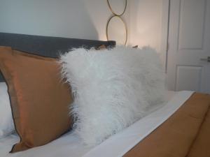 a white fluffy pillow sitting on top of a bed at Experience the Best of Houston from our Modern Urban Oasis in Houston