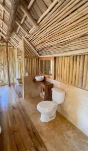 baño con aseo y lavamanos en una cabaña en Rancho Romana Ecolodge Park V-01 en El Limón