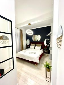Un dormitorio con una gran cama blanca y espejos en Metropole Apartments - Old City, en Bucarest