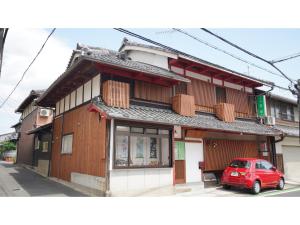 un'auto rossa parcheggiata davanti a un edificio di Uji Tea Inn - Vacation STAY 27219v a Uji