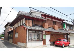 a red car parked in front of a building at Uji Tea Inn - Vacation STAY 27219v in Uji