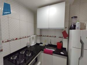a kitchen with a stove and a white refrigerator at Apartamento in Fortaleza