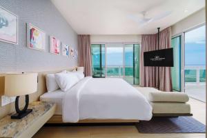 a bedroom with a large white bed and a window at Wyndham Grand Barbados Sam Lords Castle All Inclusive Resort in Saint Philip