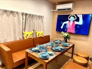 a dining room with a table and a tv with a mask at Nakanishiso 2F - Vacation STAY 30052v in Tokyo