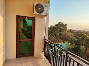 a balcony with a door and a fan at APEX Rest house of 10 rooms and pool in Yerevan