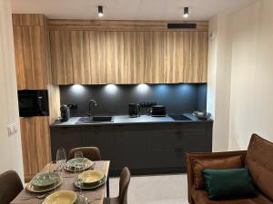 a kitchen with a table and a sink and a counter at Apartamenty Czarne Owce in Szklarska Poręba