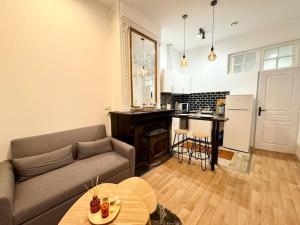 uma sala de estar com um sofá e uma cozinha em LeCosyWood1*Centre-Ville*TV*WIFI em Calais