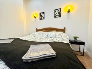 1 dormitorio con 1 cama con 2 toallas en LeCosyWood1*Centre-Ville*TV*WIFI en Calais