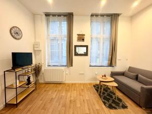 a living room with a couch and a tv at LeCosyWood1*Centre-Ville*TV*WIFI in Calais
