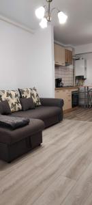 a living room with a couch and a kitchen at Warm Apartament Nou in Bacău +15 photos
