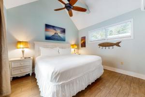 Un dormitorio con una cama blanca y un ventilador de techo. en Oceana Suite, en Key West 15 fotos más