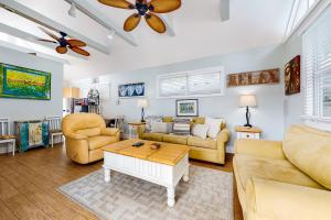 sala de estar con muebles de color amarillo y ventilador de techo en Oceana Suite, en Key West