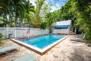 una piscina en un patio con una valla y árboles en Oceana Suite, en Key West