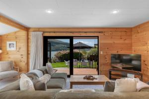 a living room with a couch and a television at Tranquil Heights in Queenstown
