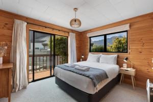 a bedroom with a bed and a large window at Tranquil Heights in Queenstown