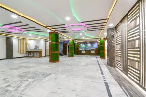 a large room with a lobby with green pillars at Flagship 79796 Hotel Royal Inn in Gulzārbāgh