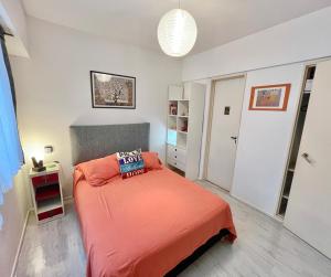 1 dormitorio con 1 cama con colcha de color naranja en Amazing & Quiet 1BD Apt in Recoleta - Location !! en Buenos Aires