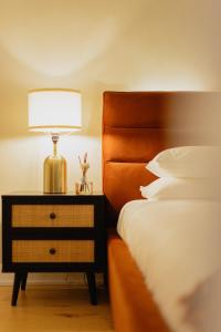 a bedroom with a bed and a lamp on a night stand at Rozenhaus Hotel - Downtown Montreal in Montreal