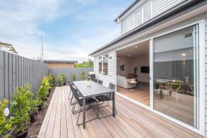 a patio with a table and chairs on a wooden deck at Surrey Sunset Sanctuary in McCrae in McCrae