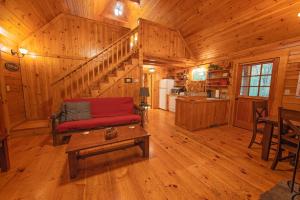 ein Wohnzimmer mit einem roten Sofa und einer Treppe in einer Hütte in der Unterkunft Cherokee Ridge Cabin Near The Ocoee River in Ocoee