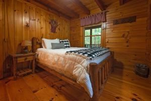 ein Schlafzimmer mit einem Bett in einem Blockhaus in der Unterkunft Cherokee Ridge Cabin Near The Ocoee River in Ocoee