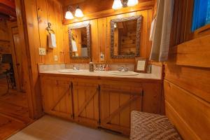 ein Badezimmer mit 2 Waschbecken und einem Spiegel in der Unterkunft Cherokee Ridge Cabin Near The Ocoee River in Ocoee
