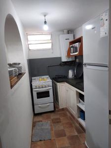 a kitchen with a white refrigerator and a stove at Quinta Valvanera in Salta
