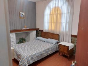 a small bedroom with a bed and a fireplace at Quinta Valvanera in Salta