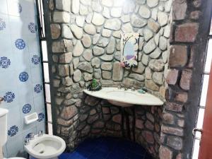 Baño de piedra con lavabo y aseo en Quinta Valvanera en Salta