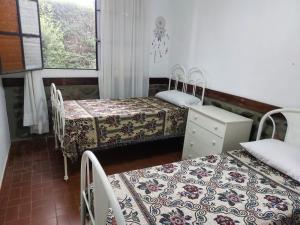 a room with two beds and a dresser and windows at Quinta Valvanera in Salta