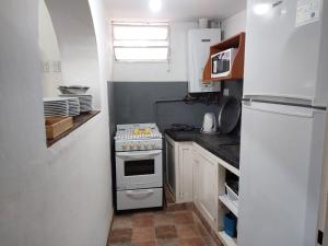 una pequeña cocina con fogones y nevera. en Quinta Valvanera en Salta