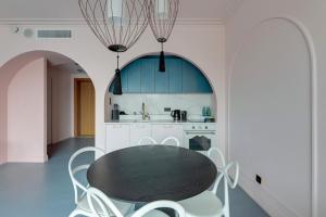 a dining room with a black table and white chairs at Deo Plaza Prestige 1 by Grand Apartments in Gdańsk