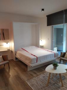 a bedroom with a large bed and a table at Apart Las Heras in Florida