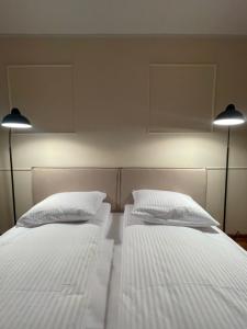 two beds in a room with two lights on the wall at Łukaszówki przy Krupówkach in Zakopane