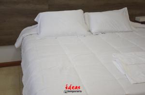 a white bed with white sheets and pillows at Ideas Temporarios in Paso de los Libres