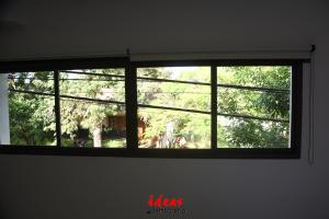 a window in a room with a view of trees at Ideas Temporarios in Paso de los Libres +7 photos