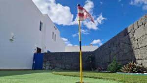 eine Flagge an einem Mast vor einer Wand in der Unterkunft VV Mapaluca MiniGolf by HH in Playa Blanca