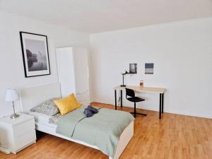 1 dormitorio con 1 cama y escritorio con silla en NEW-Berta die Kölner Vorstadtwohnung, en Bergheim