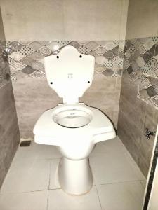 - une salle de bains avec des toilettes blanches dans une cabine dans l'établissement Ashapura Home Stay, à Kevadia