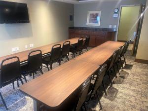 uma sala de conferências com longas mesas e cadeiras de madeira em Staybridge Suites Great Falls, an IHG Hotel em Great Falls