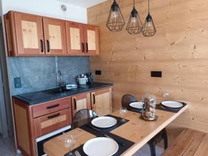 cocina con mesa con sillas y fregadero en appartement montagne- le petit Chaillol en Saint-Michel-de-Chaillol