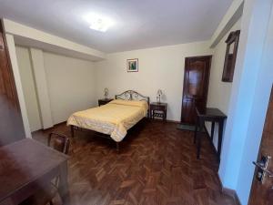 a bedroom with a bed and a wooden floor at The Hidden House Hostel in La Paz