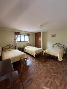 una camera con 2 letti e un pavimento in legno di The Hidden House Hostel a La Paz