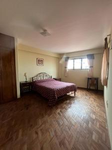 a bedroom with a bed and a wooden floor at The Hidden House Hostel in La Paz