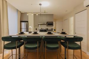 a kitchen with a large island with green bar stools at Rozenhaus Hotel - Downtown Montreal in Montreal