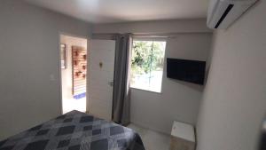 um quarto com uma cama e uma janela em POUSADA CASA DIAMANTe em Cabo Frio