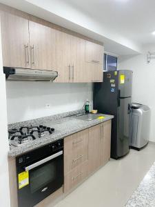 a kitchen with a stove and a refrigerator at Apartaestudio Amoblado in Valledupar